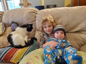 Garrett snuggles with big brother Evan and Gambit. 