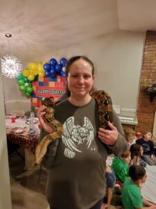 Meagan holding a python at Santino's birthday party