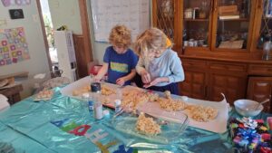 Evan's 5th birthday. Arya and Evan are working decorating on his rice crispy birthday cake. 
