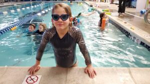 Arya at a pool for a coop swimming event. 