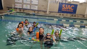 Arya at a pool for a coop swimming event with all of the coop kids. 