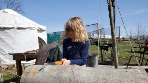 Arya working the saw on a log. 