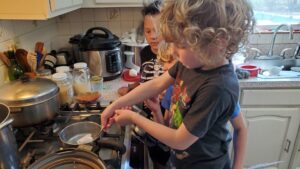 Evan dyes some eggs while Bella and Arya watch. 