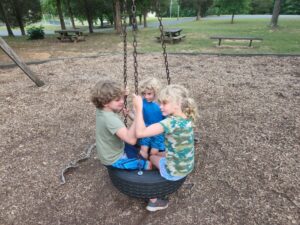 The kids made use of a tire swing they found at the playground. 