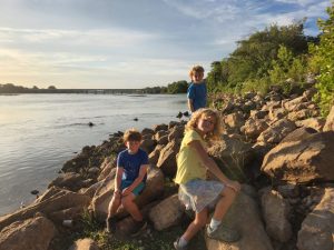 Kids alongside the river bank of the Arkansas River. 