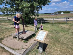 Arya works the water pump on their well. 