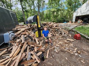 Catching up on processing firewood collected in the spring, Jarek was a helper as Alan split the wood. 