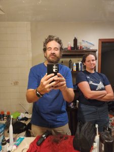 Time to tame the wild. Alan starts to trim back the mountain man beard as a satisfied Meagan looks on. 