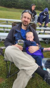 Alan is the designated Garrett keeper during games. Garrett didn't mind snuggling up when it was cool, although sometimes he wandered down to poach snacks from other unsuspecting spectators!