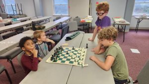 Jarek takes on a challenger at chess at one of the home school co-ops. 