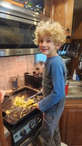 Evan helps to cook breakfast. He has quite taken to helping cook. 