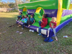 Arya's birthday party with the neighborhood kids enjoy a bouncey house obstacle course. 